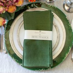 a place setting with green napkins and silverware