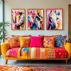 three colorful horse paintings hang on the wall above a brightly colored couch in a living room