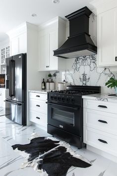 a black stove top oven sitting inside of a kitchen next to white cabinets and drawers