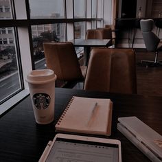 a cup of coffee and a tablet on a table with a view of the city