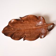 a wooden leaf shaped object sitting on top of a table