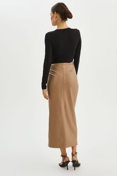 The Eileen Faux Leather Skirt is designed to make a statement with its gathered detailing and asymmetrical waistline. The high slit adds allure and allows for graceful movement. Create a show stopping look by pairing it with a form-fitting top that accentuates your curves. Leather Maxi Skirt, Form Fitting Tops, Graceful Movement, Faux Leather Skirt, Mocha, Leather Skirt, Maxi Skirt, Faux Leather, Boutique