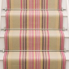 the stair treads are painted with pink, yellow and brown striped fabric on them