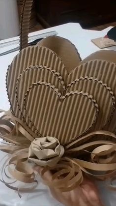 two heart shaped cakes sitting on top of a white table covered in ribbon and ribbons