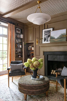 a living room filled with furniture and a fire place under a chandelier above a fireplace