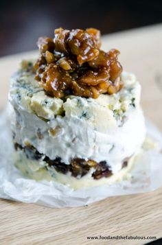 a close up of a piece of cake on wax paper with walnuts and other toppings