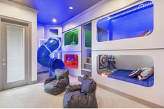 this is a kids's bedroom with bunk beds and slide in the wall,