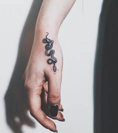 a woman's hand with a snake tattoo on it