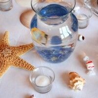 a table topped with vases filled with water and starfish