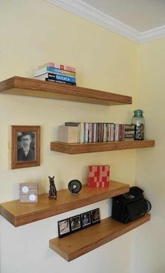 two wooden shelves with books and pictures on them