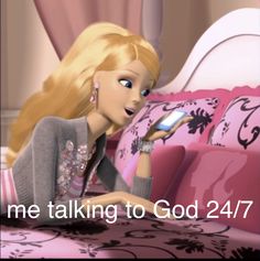 a barbie doll sitting on top of a bed holding a cell phone in her hand