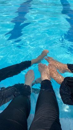 four people are in the water with their feet on each other's back legs