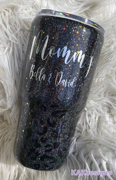 a black glitter tumbler with the words mommy and baby on it