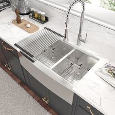 a stainless steel kitchen sink and countertop in a modern style with white marble top