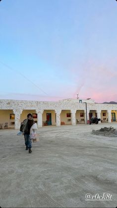 two people are walking in the middle of an empty parking lot