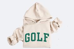 Perfect for any golf lover, this golf hoodie is relaxation itself. Made with a thick blend of cotton and polyester, it feels plush, soft and warm, a perfect choice for any cold day. In the front, there's college GOLF design, while the hood's drawstring is the same color as the base sweater for extra style points. It fits true to size, please refer to the sizing guide to find your exact size or size up for an oversized fit.  Information - Gildan® Heavy Blend™ Hoodie - 50% Cotton 50% Polyester - C Golf Stuff, Trendy Fits, Professional Style, College Hoodies, Golf Tournament