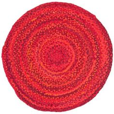 a round rug with red and orange colors on the bottom, in an oval shape