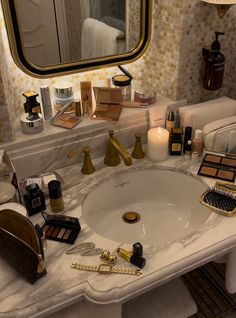 a bathroom sink with makeup and other items on it