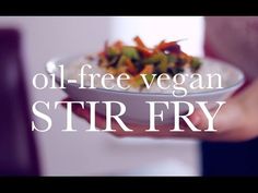 a person holding a bowl of food with the words oil - free vegan stir fry