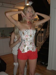 a woman in red shorts and a white corset is posing for the camera