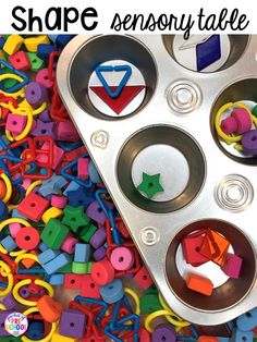 a metal tray filled with lots of colorful plastic letters and shapes that spell out the word shape