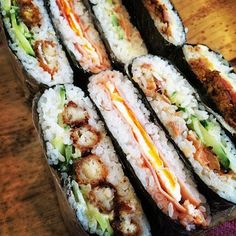 several sushi rolls sitting on top of a wooden table