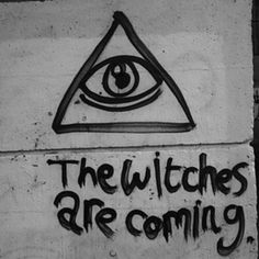 a sign that says the witches are coming with an eye drawn on it in black and white