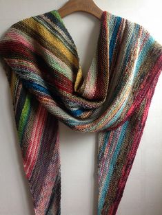 a multicolored scarf hanging on a wooden hanger