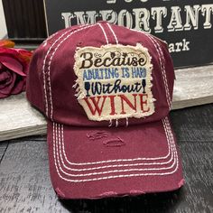 a red hat with the words because eating is fun without wine on it, sitting next to a sign