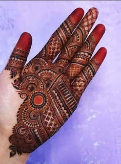 the hand is decorated with henna designs on it's fingers and palm area