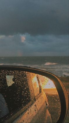 the rear view mirror of a car with rain drops on it