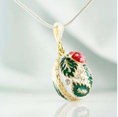 "Enameled and 24k gold plated over solid sterling silver, very cute and festive egg pendant created in the tradition of Faberge jewelry. Bright red ladybug rests between forest green leaves on white background at the top of the pendant in its front part, otherwise identical to the back of the egg. A pendant is about 0.6\" (17 mm ) without a bail. The pendant comes ready to wear with 18\" sterling silver gold plated chain, and in a gift box. If you feel that you need a longer chain, please, conta Enamel Oval Pendant Necklace For A Gift, Oval Pendant Enamel Necklace For Gift, Oval Enamel Necklace For Gift, Oval Enamel Jewelry For Gift, Traditional Gold Christmas Jewelry, Traditional Oval Necklace As Gift, Traditional Gold Jewelry For Christmas, Faberge Jewelry, Lucky Gifts