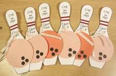 paper bowling pins with labels on them sitting on a table