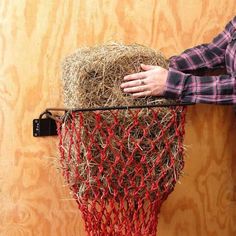 a person is holding onto a hay bale