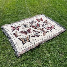 a blanket with butterflies on it laying in the grass