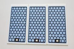 three pieces of blue and white paper with holes in the middle, on top of each other