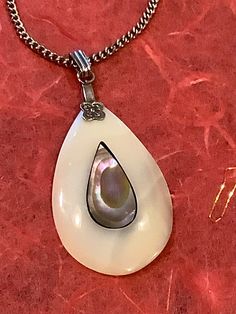 Artfully polished abalone teardrop pendant. Single piece of teardrop Mother of Pearl shell polished down the white while leaving the darker abalone shell remaining in the inner teardrop shape. 18 inch silver tone chain. Unsigned with ring clasp. Good shape with little wear.  (H114 ) Teardrop Pendant, Pearl Shell, Abalone Shell, Single Piece, Pendant Necklaces, Mother Of Pearl, Jewelry Necklace Pendant, Silver Tone, Shells