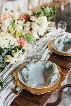 the table is set with plates and flowers