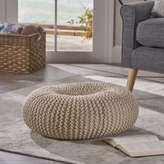 a blue knitted bean bag sits on the floor in front of a gray chair