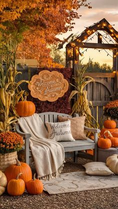 a wooden bench surrounded by pumpkins and other fall decorations in front of a welcome autumn sign