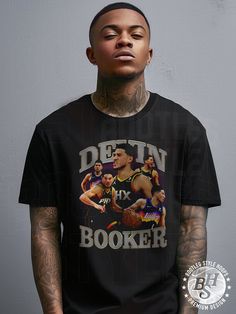 This 90s bootleg style t-shirt featuring Devin Booker on Phoenix was created by a team of designers who are true basketball fans.    Our shirts are inspired by 1990s bootleg culture where street artists created popular unofficial merchandise featuring rappers and other artists. Each shirt features bold designs and edgy typography that give it that authentic retro feel.   Take your wardrobe to the next level without breaking the bank. Get your hands on this premium classic shirt today and show yo Throwback Graphic T-shirt For College, Throwback College Graphic Print T-shirt, Throwback Graphic Print T-shirt For College, Throwback Streetwear T-shirt, Pre-shrunk, Throwback Graphic Print T-shirt For Streetwear, Throwback T-shirt With Sublimation Print For Fans, Edgy Typography, Phoenix Basketball, Vintage Basketball