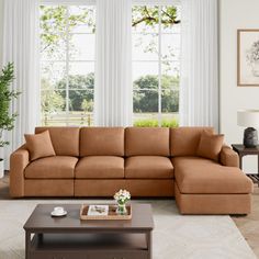 a living room filled with furniture next to two windows and a coffee table on top of a rug