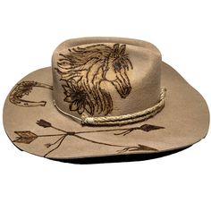 Cowboy hat custom burned by hand specifically for Bourbon Cowgirlby KC Lids. These hats are exclusive and only found here. We worked with the designer to create our very own look. 100% wool hat. One size fits all, as the interior band is adjustable to fit most. A beautiful cattleman rancher style, this distressed almond / beige colored hat is sanded and torched to a beautifully burnished and distressed finish. Firm shape (do not crush). Our artisan has hand burned a beautiful horse with flowing Custom Felt Hat For Country Events, Artisan Ranch Hat With Short Brim, Adjustable Fur Felt Hat For Kentucky Derby, Artisan Hat With Short Brim For Ranch, Artisan Short Brim Hat For Ranch, Felt Cap Hat For Country Events, One Size, Felt Cap Hat For Country Events, Felt Cap For Country Events, Custom Flat Brim Felt Hat For Western-themed Events