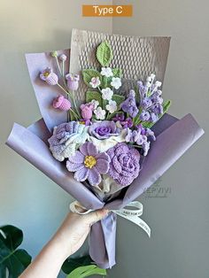 a person holding a bouquet of flowers in front of a wall with the words type c on it