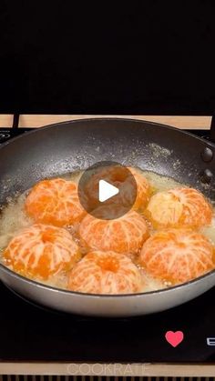 oranges being cooked in a frying pan on top of an electric burner