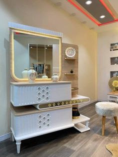 the interior of a salon with white furniture and gold accessories on display in front of a mirror