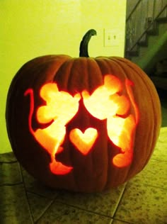 a carved pumpkin with hearts on it