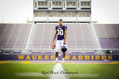 a football player standing on the sidelines in front of an empty bleachers