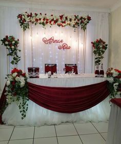 the table is set up with flowers and candles for an elegant wedding reception in red and white