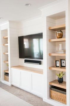 a flat screen tv sitting on top of a wooden shelf